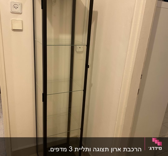 ארון תצוגה מזכוכית עם מסגרת מתכת בפינת חדר